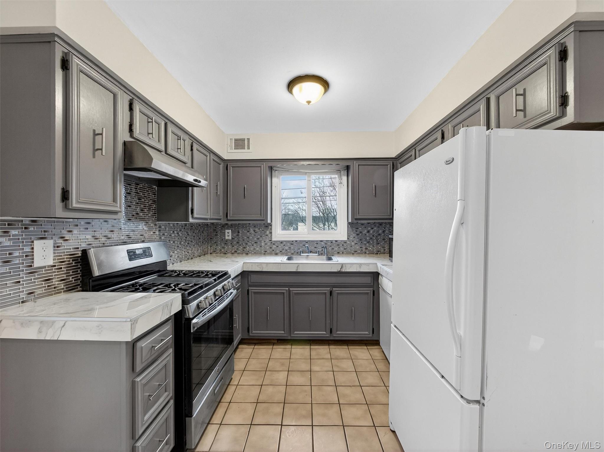 69 Gerow Avenue Spring Valley, NY 10977 - Photo 2 of 18 a kitchen with stainless steel appliances granite countertop a stove a refrigerator and a sink