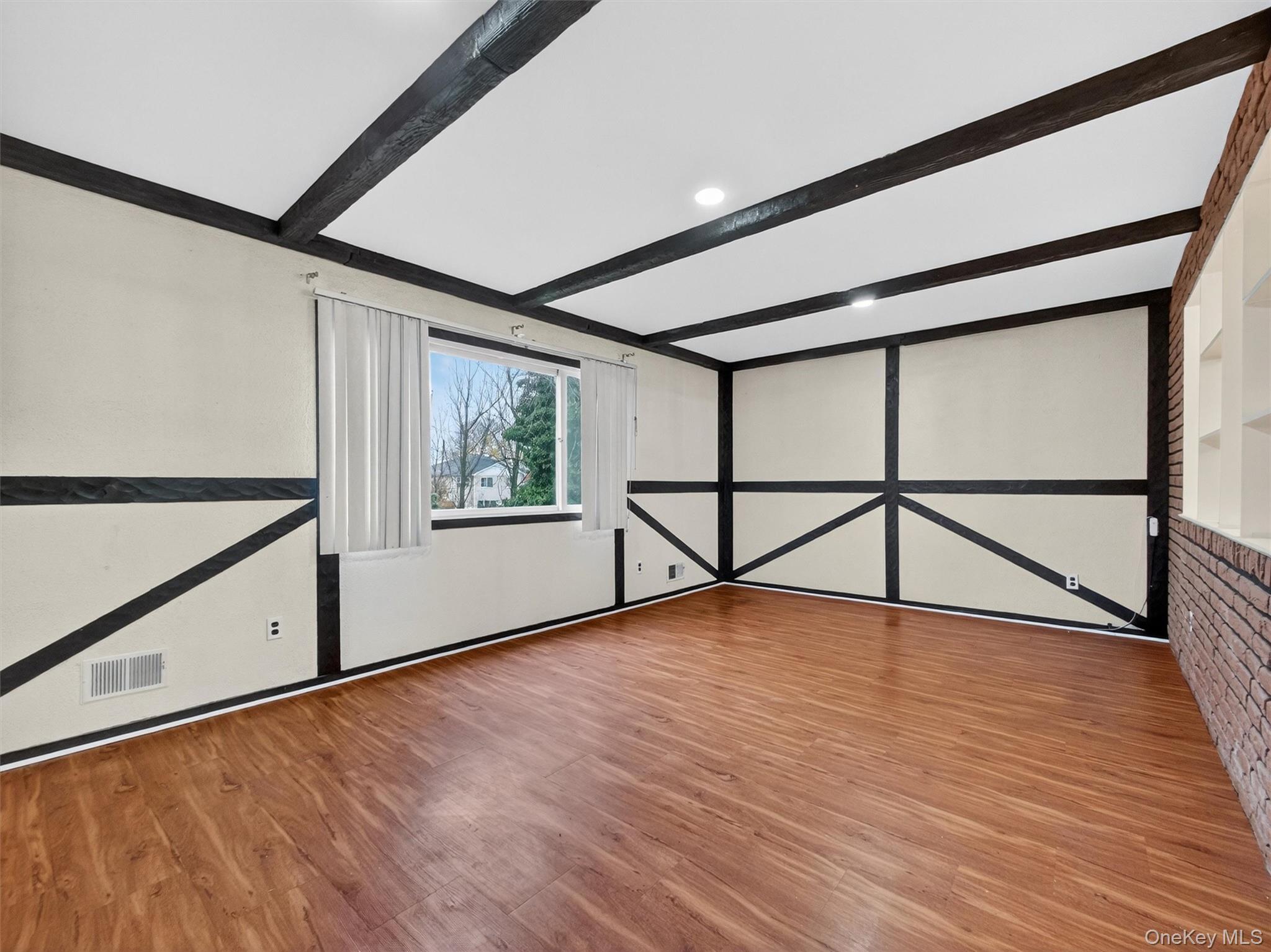 69 Gerow Avenue Spring Valley, NY 10977 - Photo 4 of 18 a view of an empty room with wooden floor and paintings on the walls