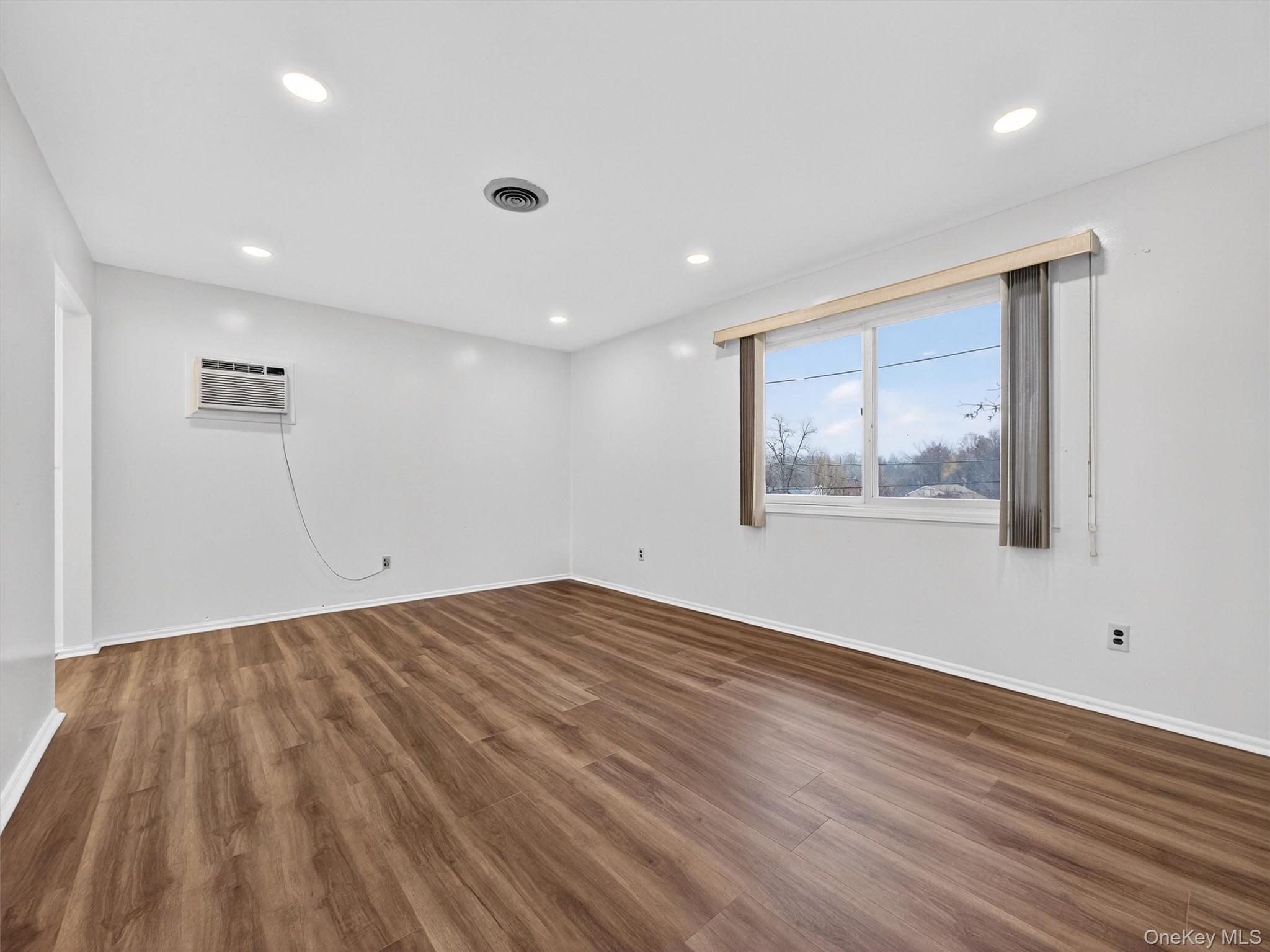 69 Gerow Avenue Spring Valley, NY 10977 - Photo 7 of 18 a view of an empty room with wooden floor and window