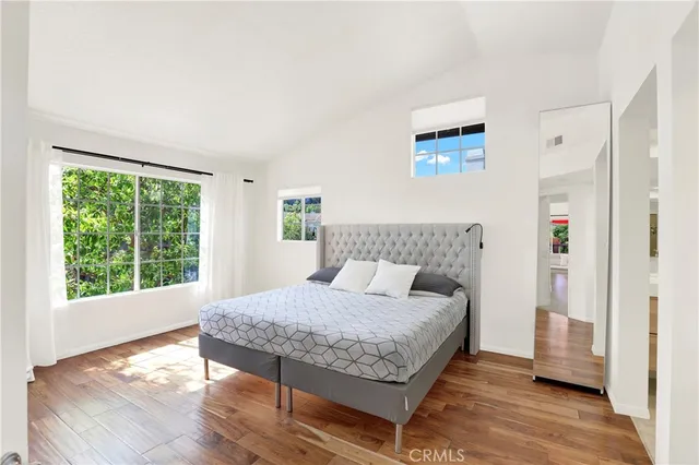 a bedroom with a bed and wooden floor