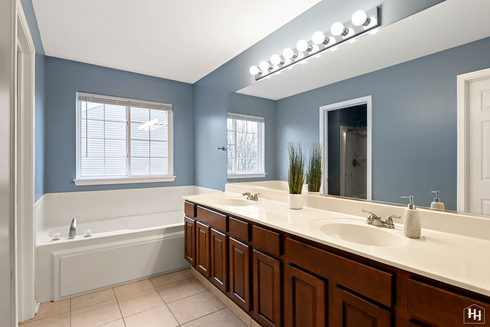 1389 Collins Drive Cary, IL 60013 - Photo 23 of 39 a bathroom with a tub a sink double vanity and a mirror