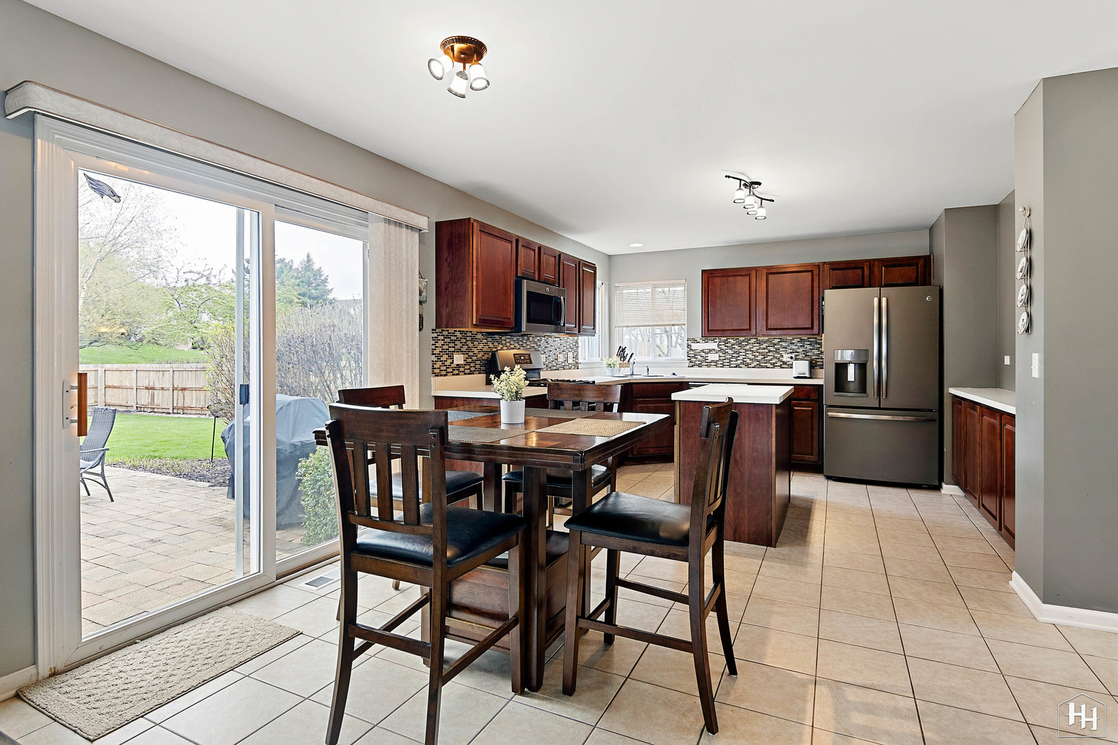 1389 Collins Drive Cary, IL 60013 - Photo 10 of 39 a kitchen with stainless steel appliances granite countertop a stove top oven a sink dishwasher a dining table and chairs with wooden floor