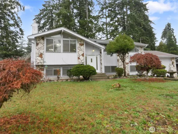 a front view of house with yard and trees
