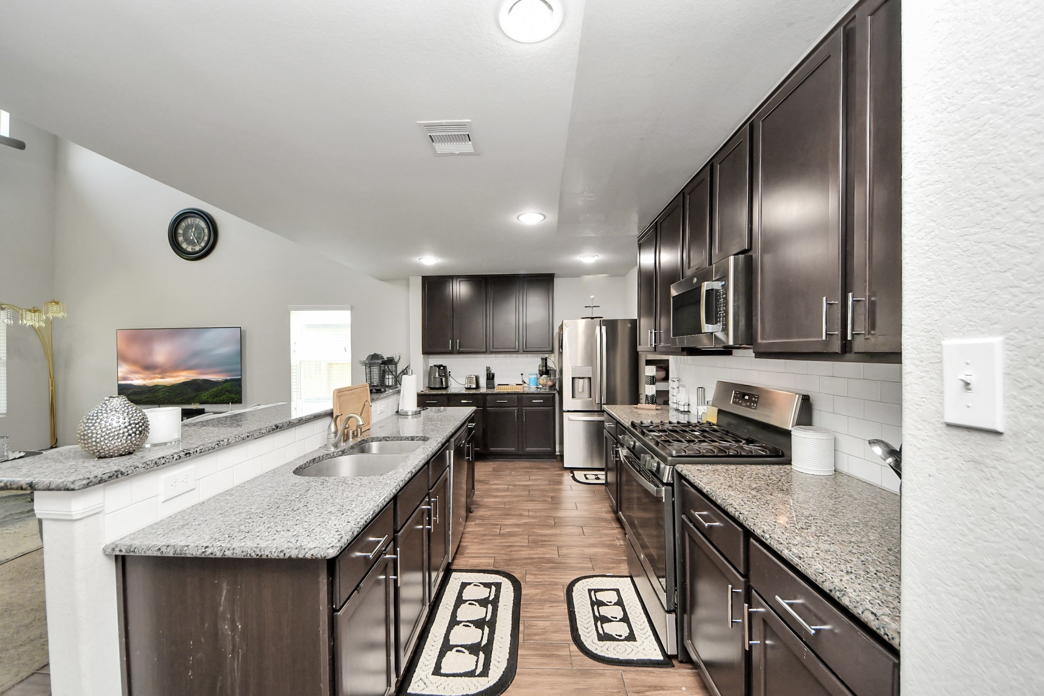 2643 Ridgeback Drive Rosenberg, TX 77471 - Photo 12 of 46 Modern kitchen with sleek dark cabinetry, stainless steel appliances, and a breakfast bar.