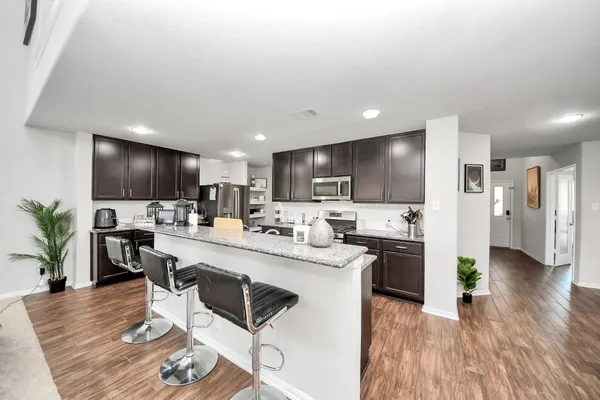 a kitchen with lots of counter top space refrigerator and chairs