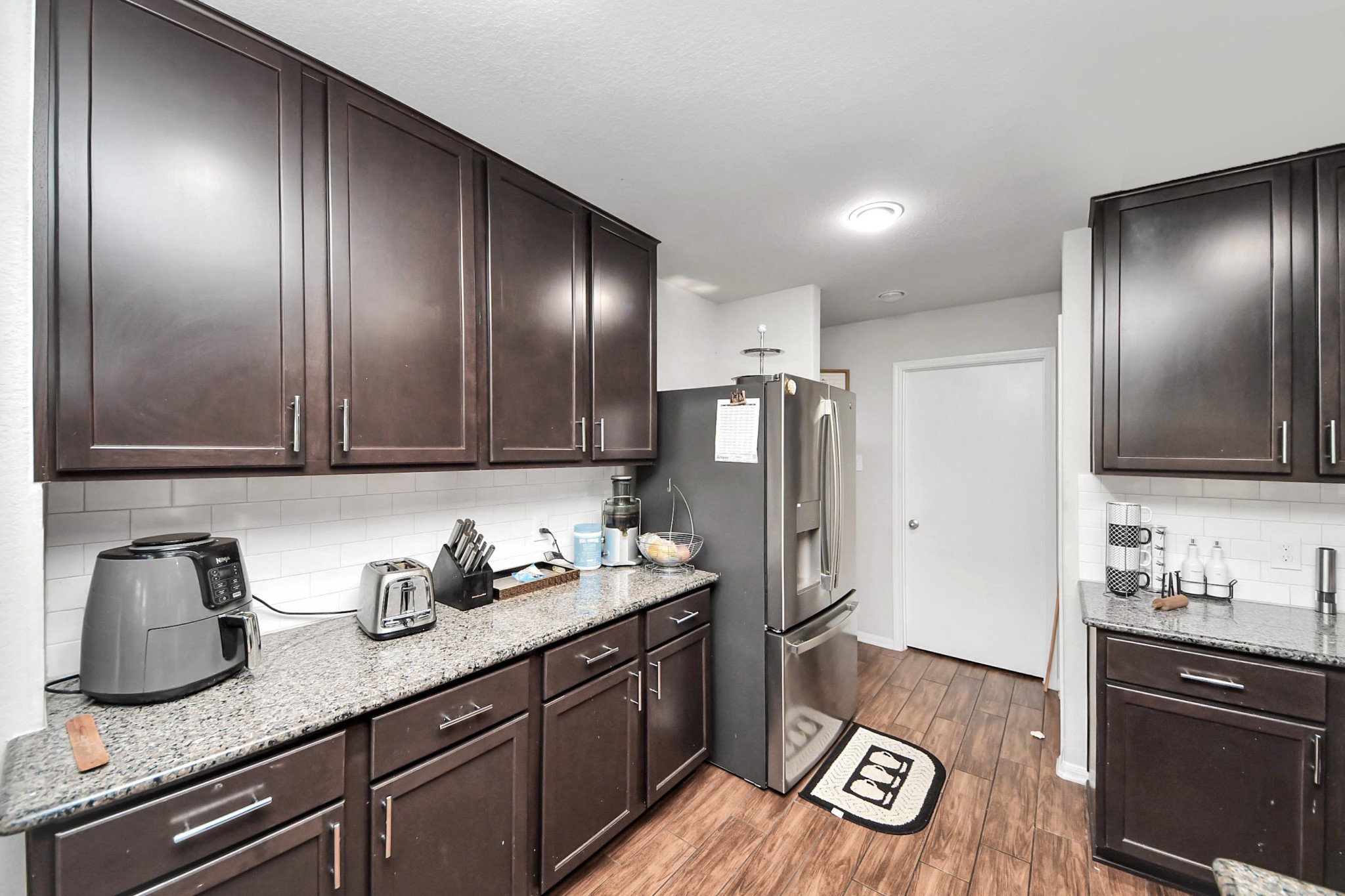 2643 Ridgeback Drive Rosenberg, TX 77471 - Photo 18 of 46 Open-concept kitchen showcasing upper and lower cabinetry and granite counters