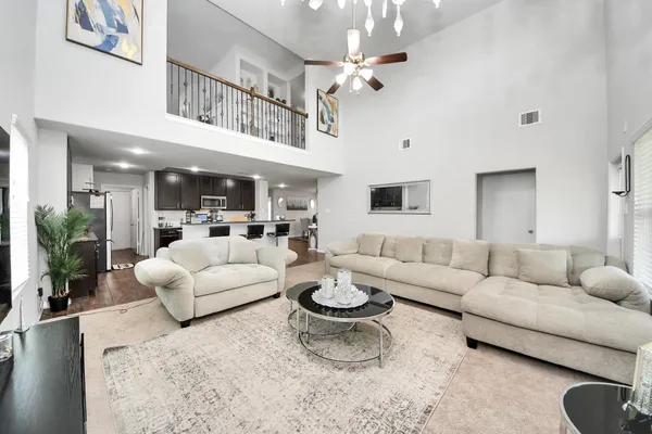 a living room with furniture a flat screen tv and kitchen view