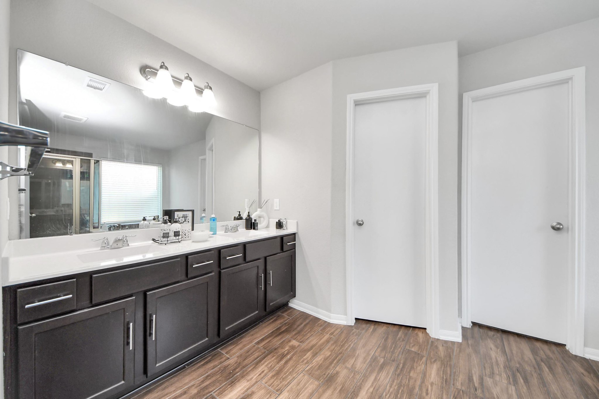 2643 Ridgeback Drive Rosenberg, TX 77471 - Photo 25 of 46 Dual vanity, separate soaking tub and glass-enclosed shower with wood-look tile flooring.
