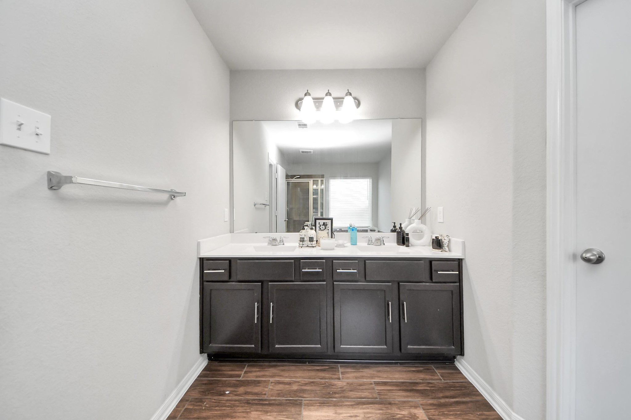 2643 Ridgeback Drive Rosenberg, TX 77471 - Photo 27 of 46 Dual vanity, separate soaking tub and glass-enclosed shower with wood-look tile flooring.