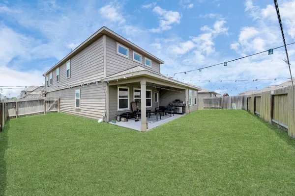 a view of backyard with table and chairs and potted plants