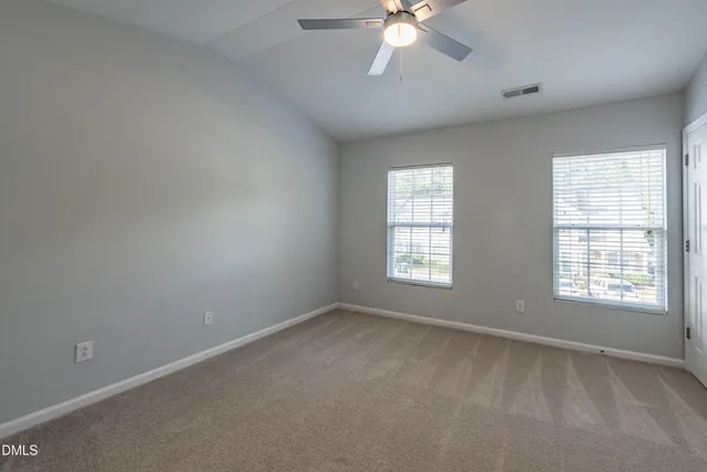 an empty room with closet and windows