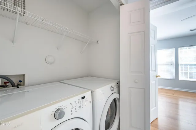 an empty room with chandelier fan and windows