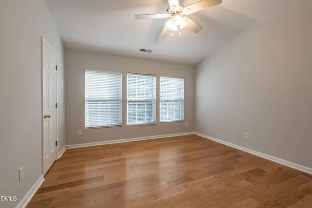 an empty room with wooden floor and mirror