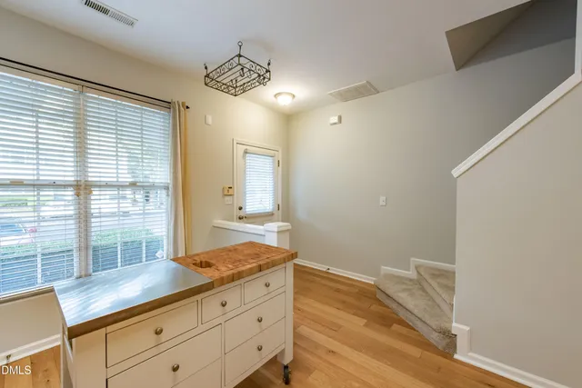 a kitchen with stainless steel appliances granite countertop a refrigerator a stove a sink dishwasher and white cabinets with wooden floor