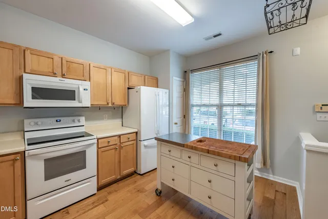 an empty room with wooden floor chandelier fan and window