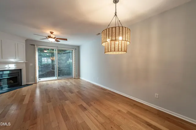 an empty room with wooden floor a chandelier