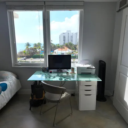 a view of a workspace with furniture and a window