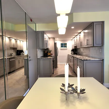 a kitchen with stainless steel appliances kitchen island granite countertop a refrigerator a stove a sink a microwave and island