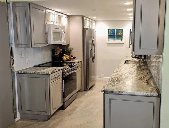 a kitchen with granite countertop a sink stove and refrigerator