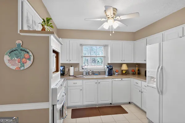 a kitchen with a sink a stove a refrigerator and a window