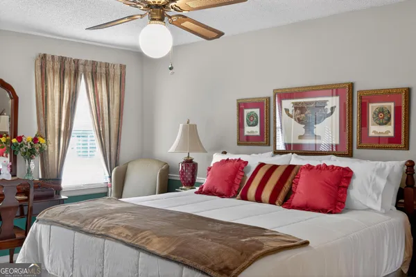 a bedroom with a large bed and a chandelier