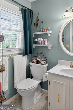 a white toilet sitting next to a bathroom sink and a window