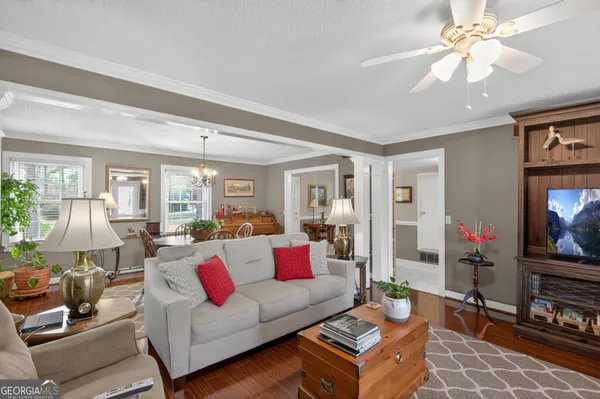 a living room with furniture a flat screen tv and a floor to ceiling window