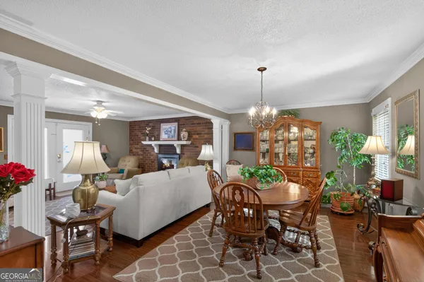 a dining room with furniture a potted plant and a chandelier