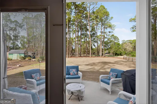 a view of yard from deck with patio