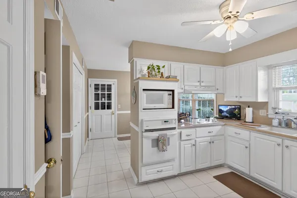 a kitchen with white cabinets and white appliances