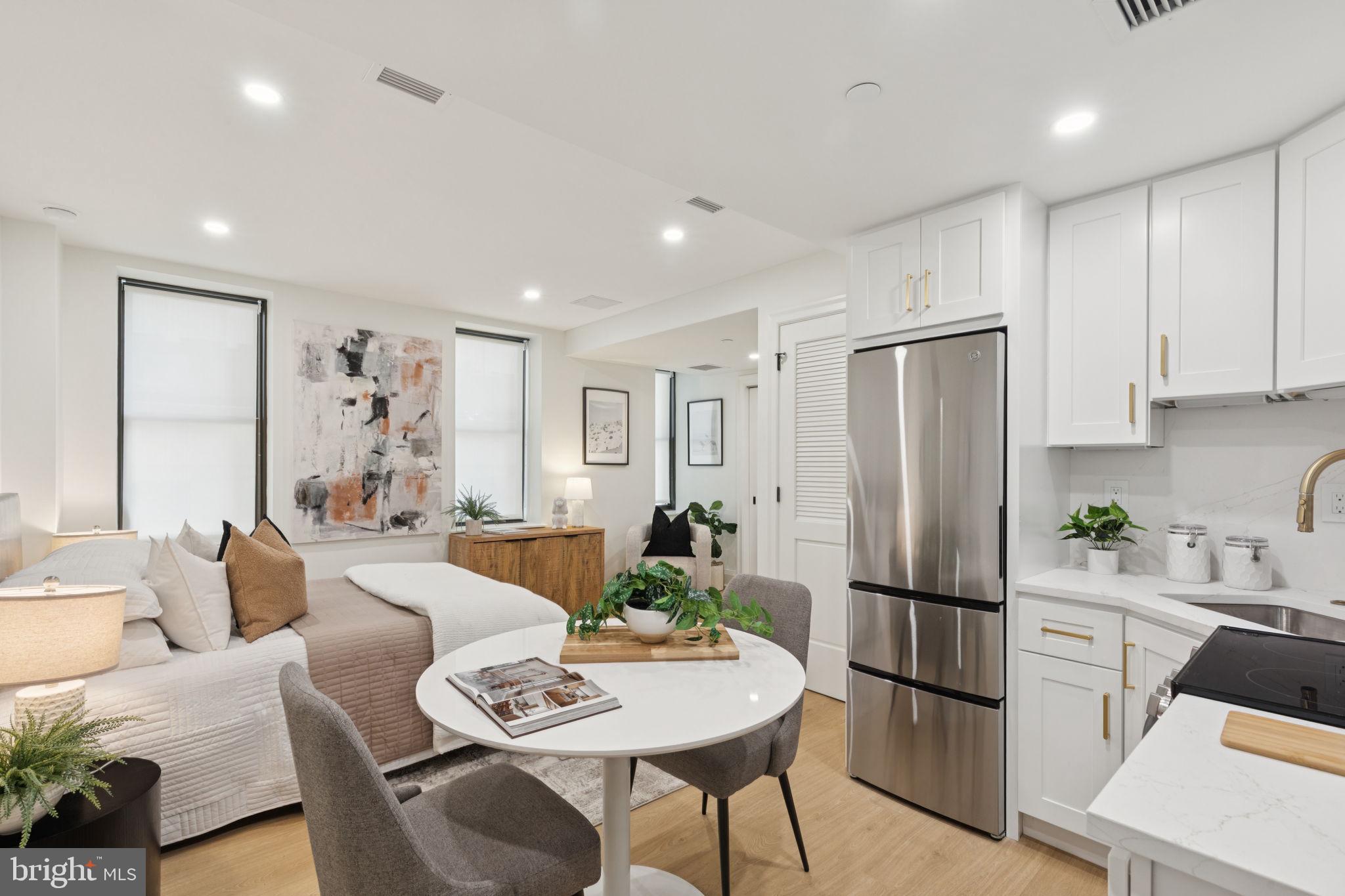 135 South 19th Street, Unit 403 Philadelphia, PA 19103 - Photo 1 of 19 a living room with furniture a refrigerator and a dining table with wooden floor