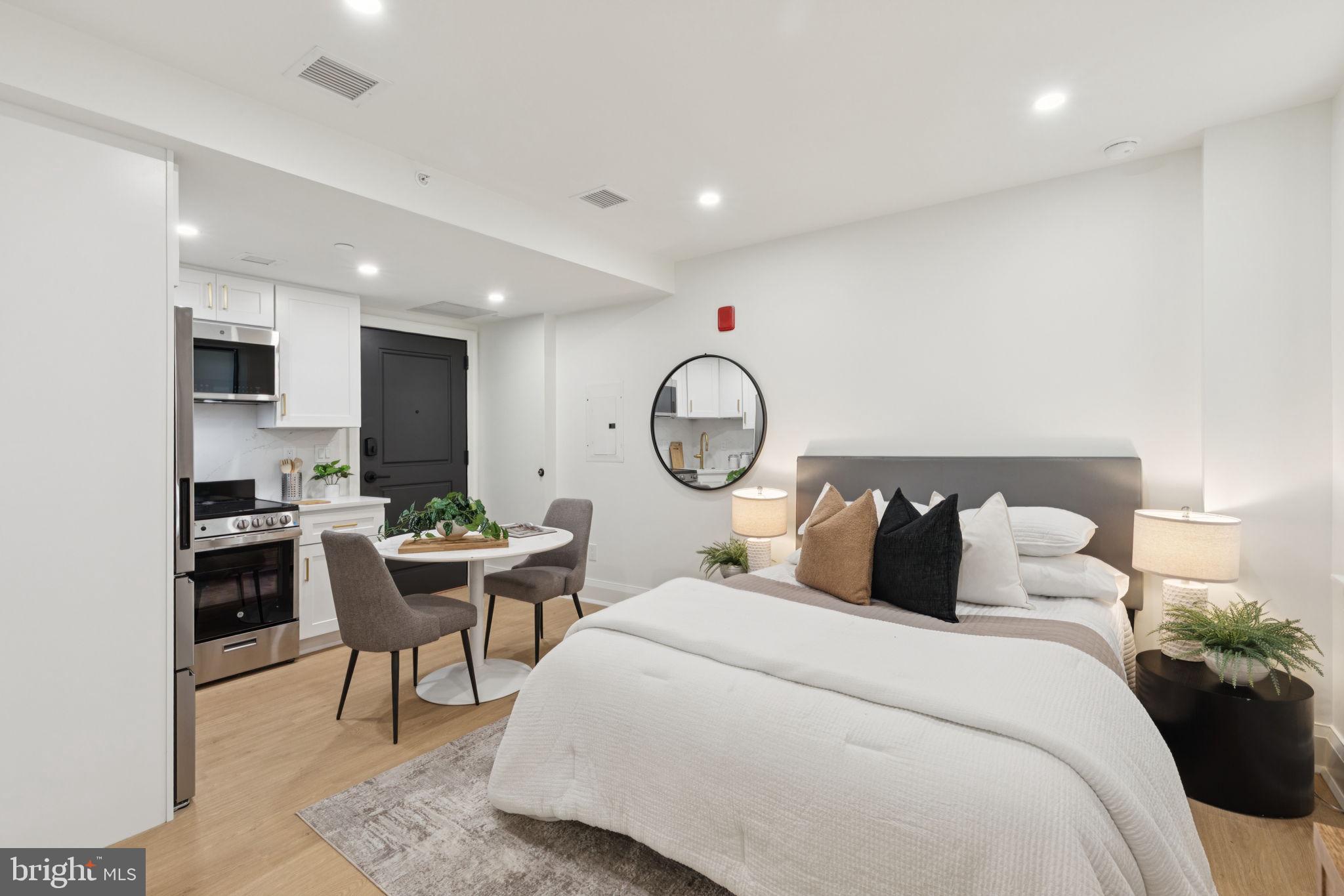 135 South 19th Street, Unit 403 Philadelphia, PA 19103 - Photo 5 of 19 a bedroom with a bed a table and a potted plant