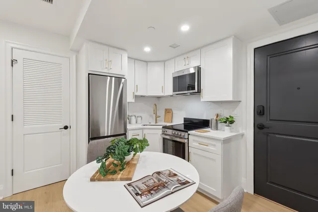a kitchen with stainless steel appliances granite countertop a refrigerator sink and stove