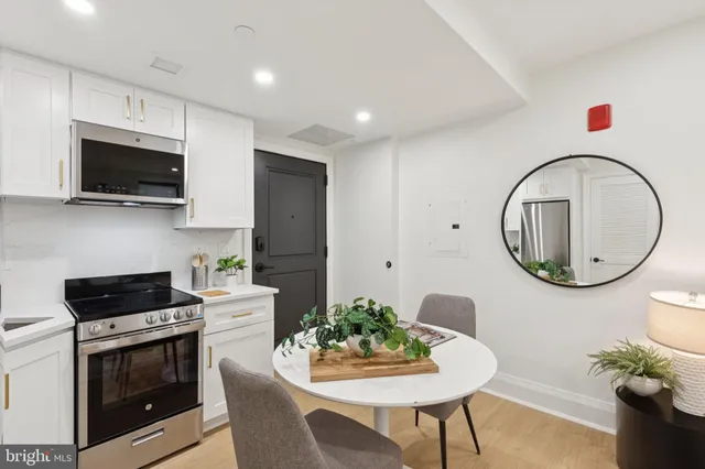 a kitchen with stainless steel appliances granite countertop a stove a microwave a sink a refrigerator and cabinets