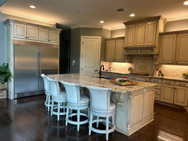 a kitchen with granite countertop stainless steel appliances a sink and a refrigerator