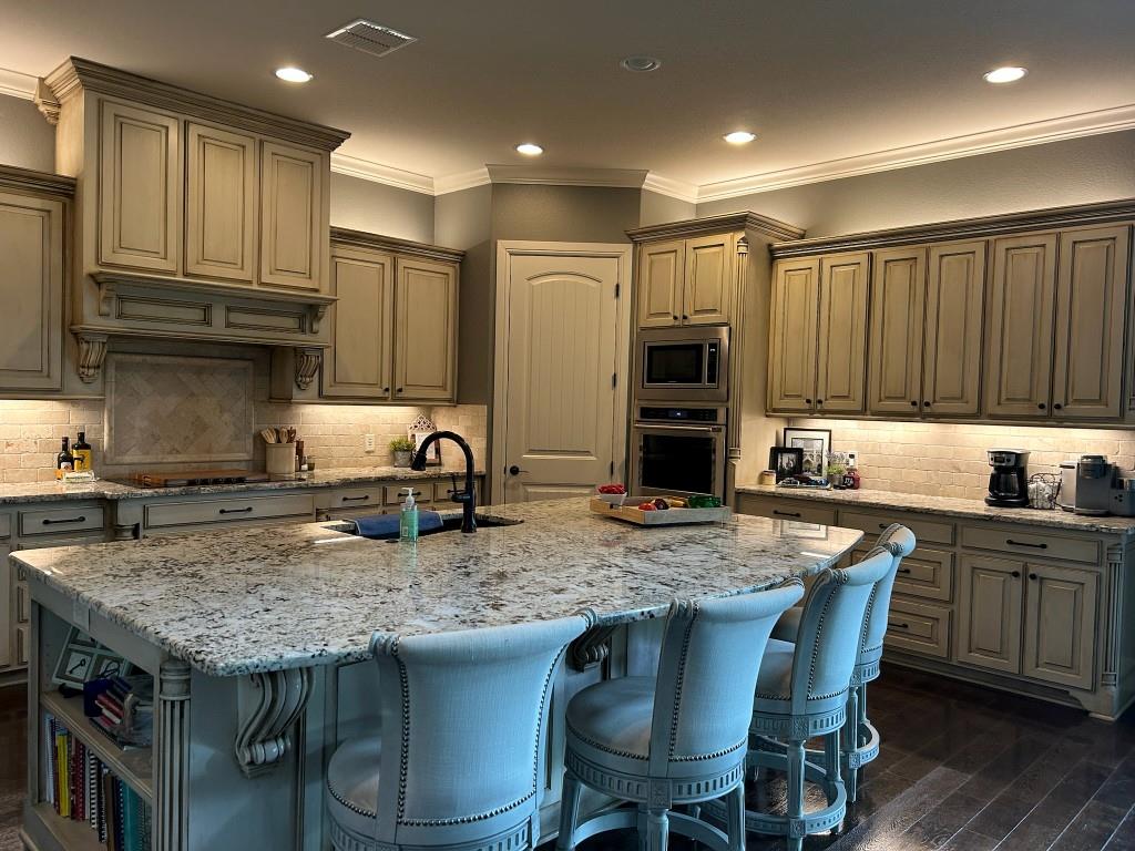 470 Granite Way Jacksboro, TX 76458 - Photo 12 of 22 a kitchen with granite countertop a table chairs sink refrigerator and cabinets