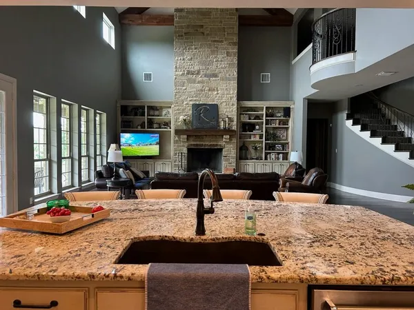 a kitchen with kitchen island granite countertop a sink and a stove