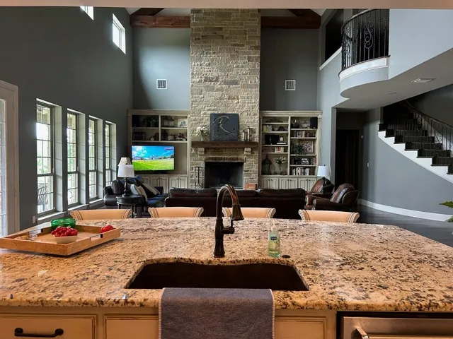 a kitchen with kitchen island granite countertop a sink and a stove