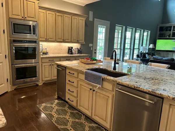 a kitchen with stainless steel appliances granite countertop a stove a sink and a microwave