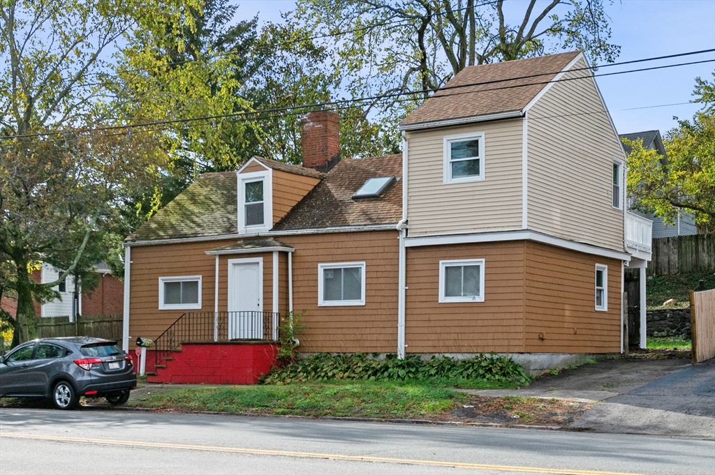 a yellow house with red door and more windows