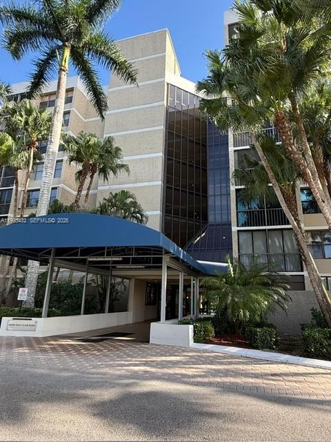 16300 Golf Club Road, Unit 208 Weston, FL 33326 - Photo 2 of 25 a front view of a house with a garden