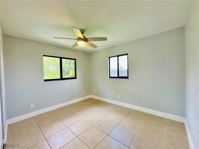 a view of a livingroom with a chandelier fan and windows