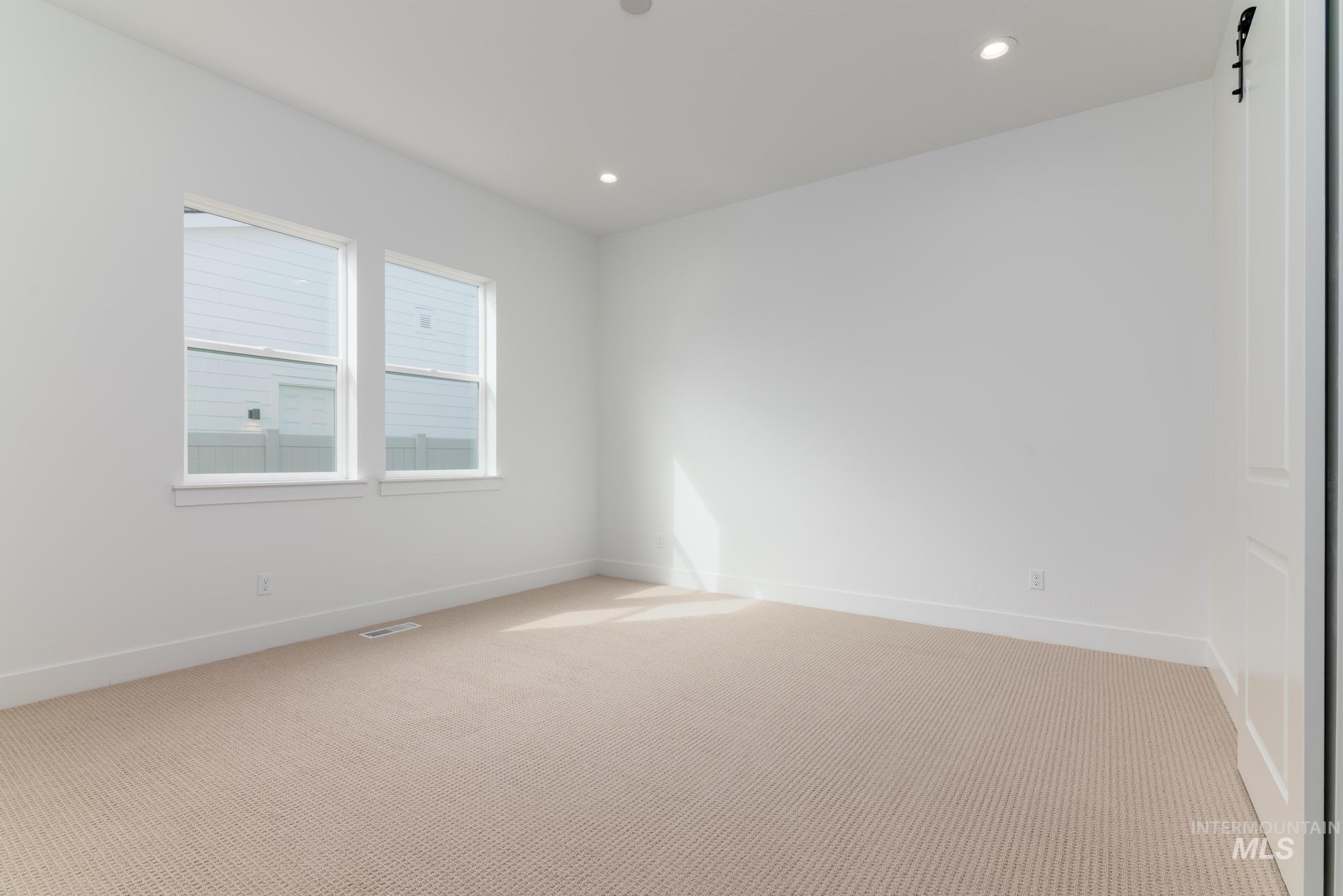 8531 West Chamblee Street Star, ID 83669 - Photo 14 of 37 Spare room featuring light colored carpet, a barn door, and recessed lighting