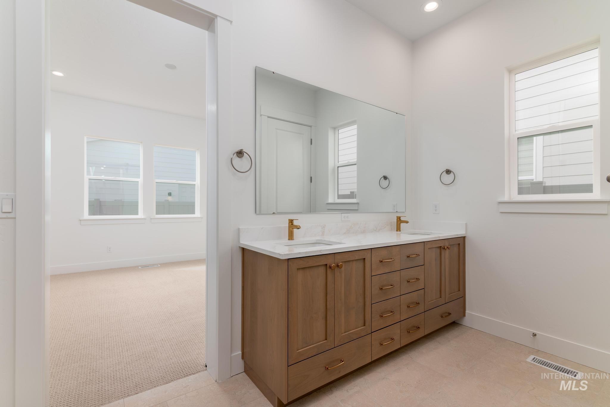 8531 West Chamblee Street Star, ID 83669 - Photo 16 of 37 Full bath with double vanity, recessed lighting, light carpet, and light tile patterned floors