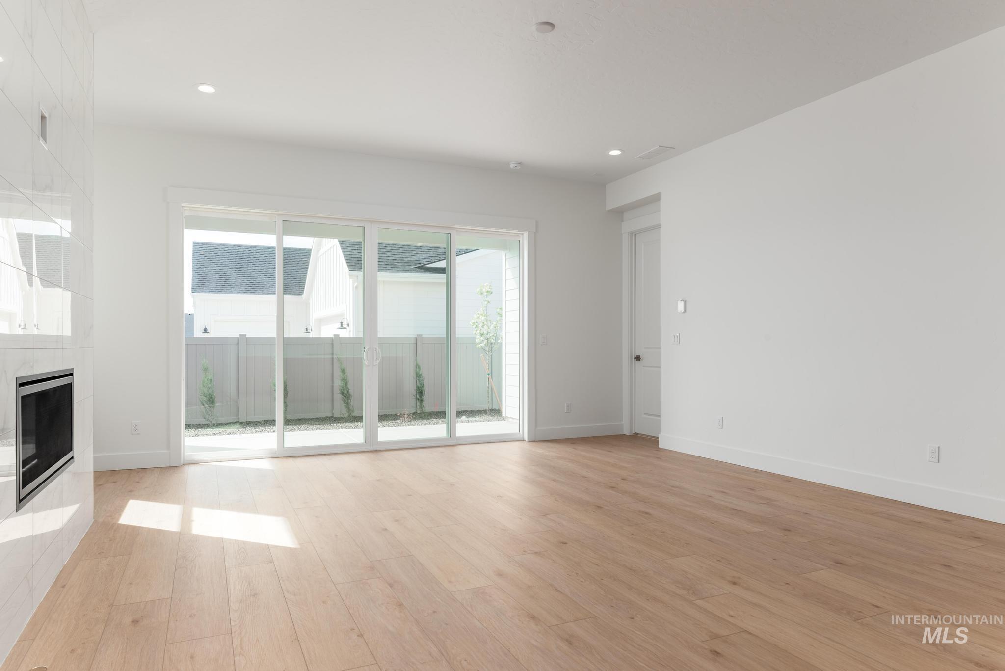 8531 West Chamblee Street Star, ID 83669 - Photo 4 of 37 Unfurnished living room featuring light wood finished floors, a fireplace, and recessed lighting