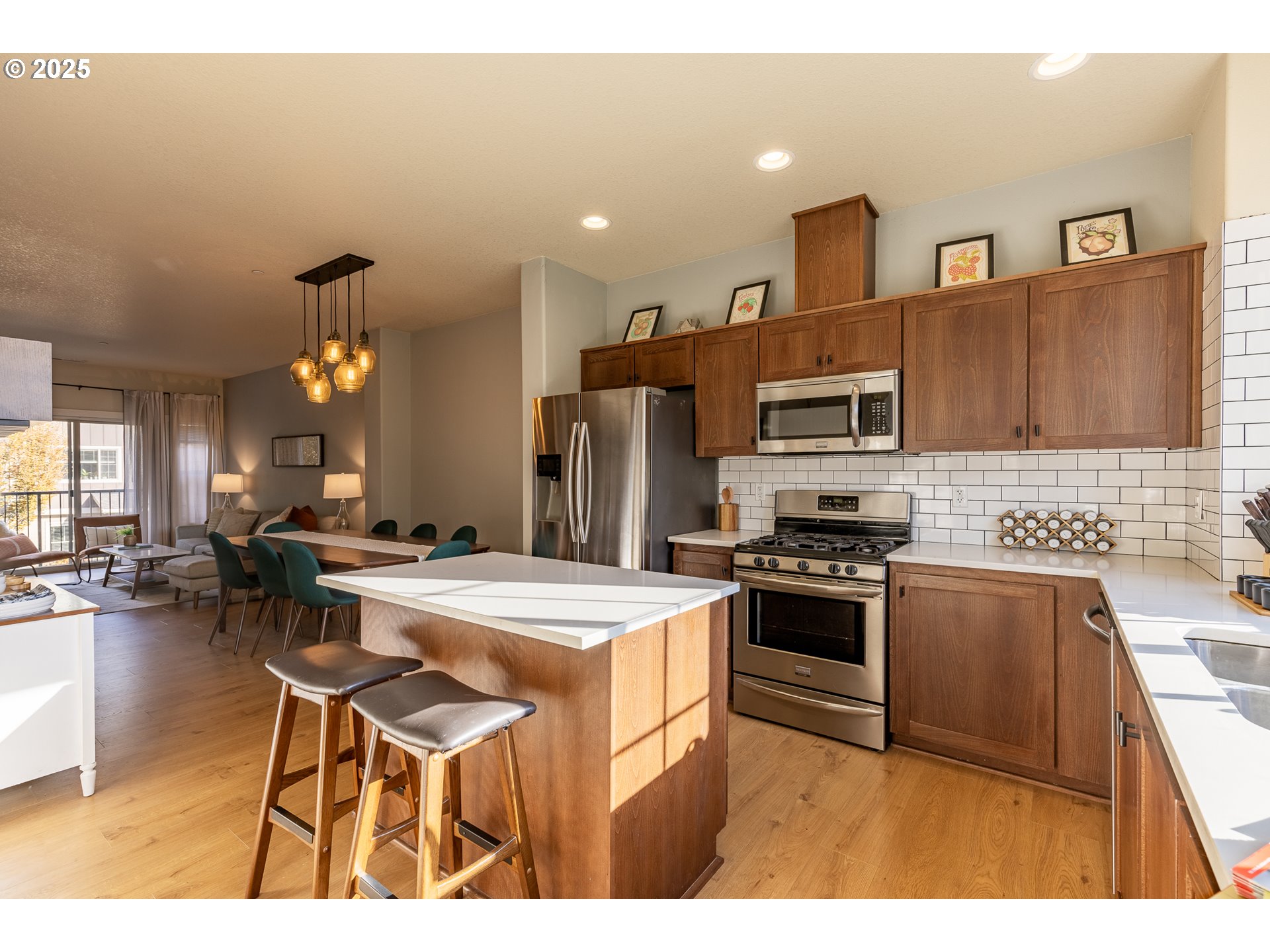 7974 Northeast Heiser Street Hillsboro, OR 97006 - Photo 12 of 32 a kitchen with stainless steel appliances kitchen island a table and chairs in it