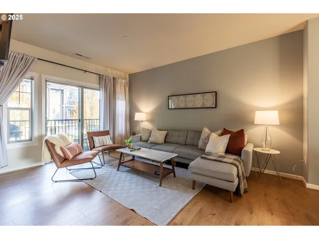 a living room with furniture a large window and a flat screen tv