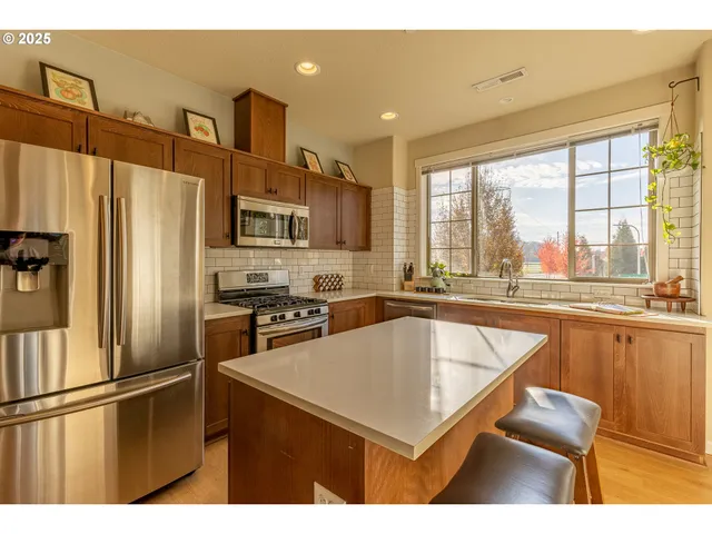 a kitchen with stainless steel appliances a refrigerator sink and microwave