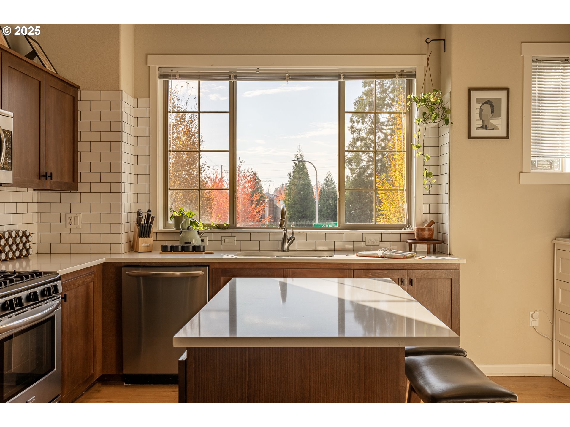 7974 Northeast Heiser Street Hillsboro, OR 97006 - Photo 9 of 32 a kitchen with kitchen island granite countertop a sink a counter top space and stainless steel appliances