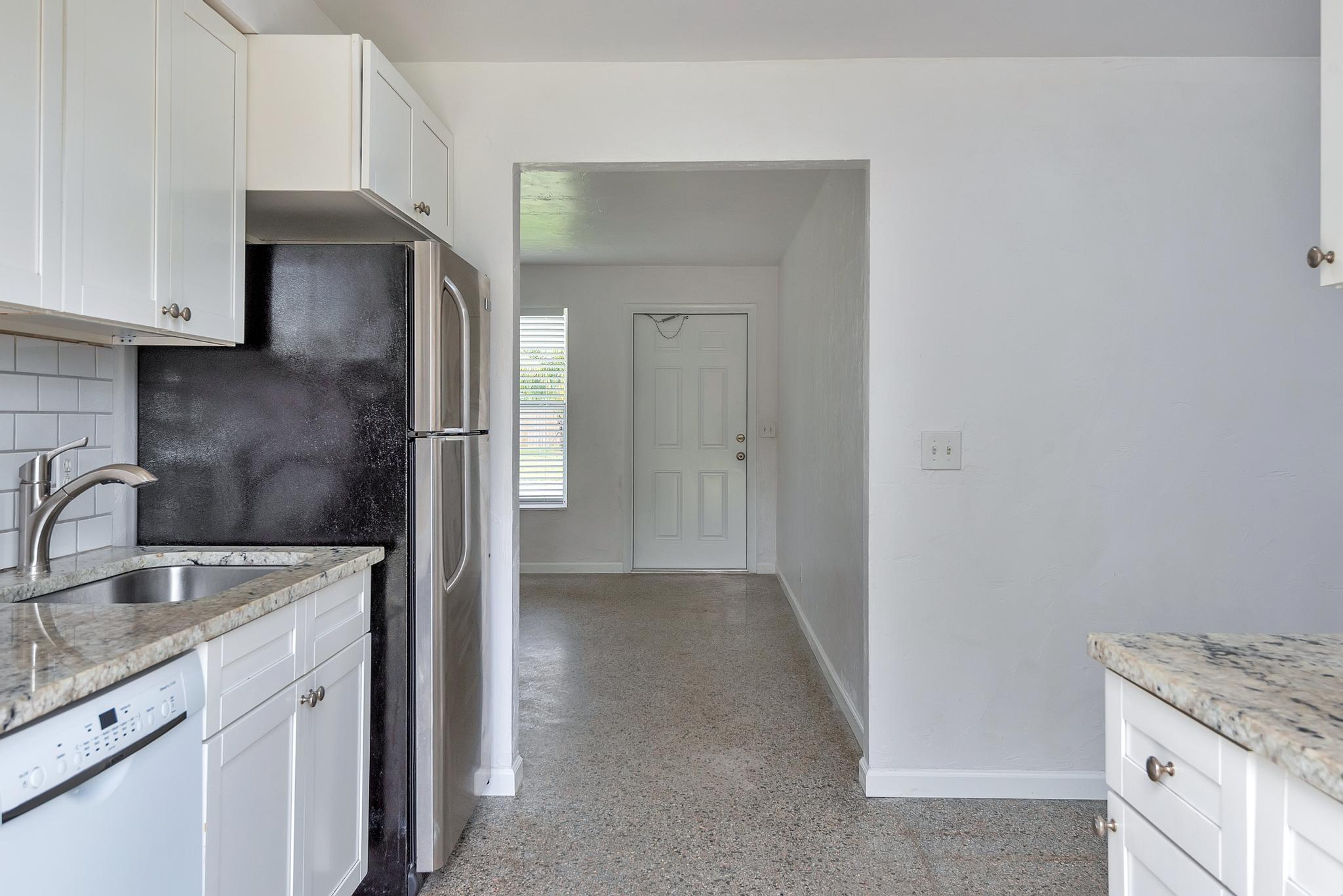 4882 Jefferson Road Delray Beach, FL 33445 - Photo 11 of 41 a kitchen with stainless steel appliances granite countertop a sink and a refrigerator
